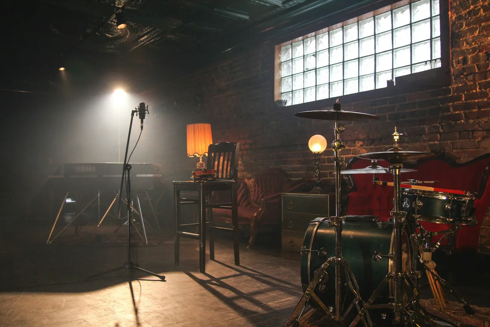 A band rehearsing in a dim room with a drum kit